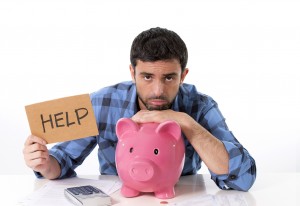 man in stress with piggy bank in bad financial situation